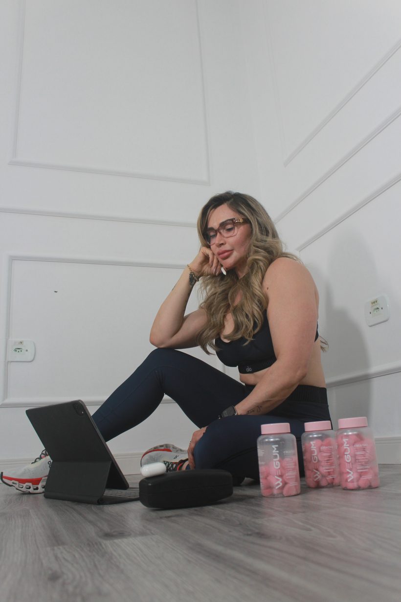 Mulher com o notebook e os potes de WEGUM ao lado